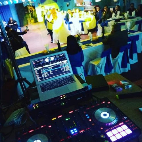 Controlador de DJ con invitados bailando en la pista