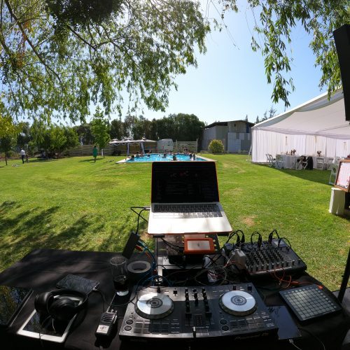 Equipo de DJ montado al aire libre junto a la piscina para un evento